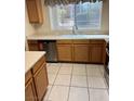 Functional kitchen with stainless steel dishwasher, window view, and wood cabinetry at 830 Carnegie St # 1811, Henderson, NV 89052