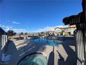 Community pool and spa area with tiled trim, promising relaxation and recreation under the clear blue sky at 890 Ripple Way, Las Vegas, NV 89110