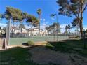 Outdoor tennis court surrounded by mature trees, offering a recreational space in a picturesque setting at 890 Ripple Way, Las Vegas, NV 89110