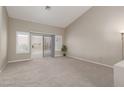 Spacious carpeted living room with high ceilings, large windows, and a sliding glass door at 8904 Marble Dr, Las Vegas, NV 89134