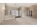 Bright living room featuring neutral carpeting, vaulted ceilings, and multiple windows for natural light at 8904 Marble Dr, Las Vegas, NV 89134