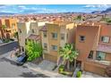 Charming townhomes with exteriors, garages, landscaping, and a view of the mountains in the distance at 9323 Best Ct, Las Vegas, NV 89178