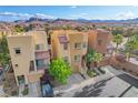 Lovely townhomes with beautiful exteriors, garages, landscaping, and a view of the mountains in the distance at 9323 Best Ct, Las Vegas, NV 89178