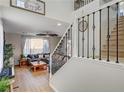 Stylish living room with a staircase featuring black iron railings and a large window at 10004 Pasque Flower Ct, Las Vegas, NV 89178