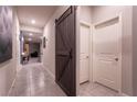 Hallway with tile flooring, wooden barn door, and neutral wall color to complement any decor at 10125 Sequoia Falls Pl, Las Vegas, NV 89149