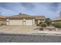 Traditional single-story home with desert landscaping and a three car garage at 1022 Atticus Ave, Henderson, NV 89015