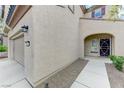 Inviting front entrance with stucco exterior, arched entryway, and a well-kept front yard at 2617 Romarin Ter, Henderson, NV 89044