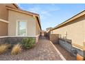 Property side yard showing brick paver pathway, desert landscaping, and backyard access at 283 Fossil Falls St, Henderson, NV 89015
