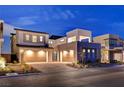 Exterior of a modern two-story home with a three-car garage and paver driveway and desert landscaping at 472 Windstone Crest Ave, Las Vegas, NV 89138