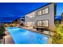 A stunning backyard features a long rectangular pool with ample seating and manicured landscaping at 472 Windstone Crest Ave, Las Vegas, NV 89138