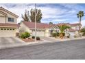 Street view of a single story home with a two car garage and desert landscaping in the front yard at 50 Mesquite Village Cir, Henderson, NV 89012