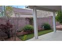 A cozy backyard featuring a covered patio, landscaped garden, and artificial turf, perfect for outdoor relaxation at 6339 Sharp Rock Ct, Las Vegas, NV 89139