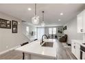 Open floor plan with stairs and a modern kitchen adjacent to the cozy living room at 712 Monroe Hill Pl, Henderson, NV 89011