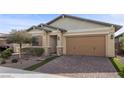 Charming single-story home featuring desert landscaping, a brick driveway, and a two-car garage at 732 Rosewater Dr, Henderson, NV 89011