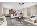 Bright, open-concept living room features modern decor, including a ceiling fan and stylish furniture at 732 Rosewater Dr, Henderson, NV 89011