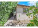 Cozy home exterior with desert landscaping, walkway and flowering bushes at 916 Putnam Ave, North Las Vegas, NV 89030