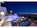 Outdoor dining on patio next to a sparkling pool, palm trees, and privacy fence at dusk at 794 Willits St, Las Vegas, NV 89138
