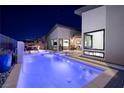 Backyard pool features bright blue lighting, landscaping, and a modern design at 794 Willits St, Las Vegas, NV 89138