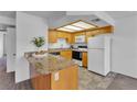Bright kitchen featuring laminate countertops, light wood cabinets, and white appliances at 8410 Eldora Ave # 2045, Las Vegas, NV 89117