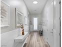 Bright hallway with modern white wood paneling, light-toned wood floors, and stylish decor at 12438 Heritage Bend Dr, Las Vegas, NV 89138
