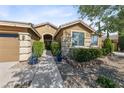 Beautiful home features attractive stonework, manicured bushes, and a covered front porch at 496 Grassrange Ln, Henderson, NV 89052