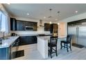 Modern kitchen featuring dark wood cabinets, stainless steel appliances, and a granite countertop island with seating at 8637 Home Gate Ct, Las Vegas, NV 89113