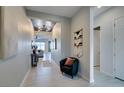 Inviting entryway with neutral walls, wood-look tile floors, modern decor, and seamless transition to living spaces at 9974 Petroglyph Canyon Ave, Las Vegas, NV 89166