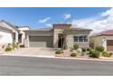 Charming single story home with a brick driveway, desert landscaping, and a two car garage at 9974 Petroglyph Canyon Ave, Las Vegas, NV 89166