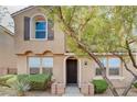 Inviting two-story townhome with an arched entry, shutters, and desert-style landscaping at 11036 Mount Hunter St, Las Vegas, NV 89179