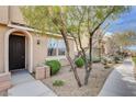 Charming townhome featuring an arched front door, desert landscaping, and a sidewalk at 11036 Mount Hunter St, Las Vegas, NV 89179
