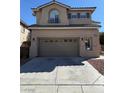 Neutral-colored two-story home featuring an attached garage and tiled roof with a paved driveway at 10393 Trailing Dalea Ave, Las Vegas, NV 89135