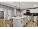 Modern kitchen island featuring a quartz countertop, white cabinetry, and stylish pendant lighting at 1660 Izabella Ave, Las Vegas, NV 89169