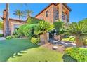 An exquisite home showcasing lush landscaping, stone accents, and well manicured turf at 1795 Anelli Ct, Henderson, NV 89012