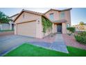 Attractive two-story home featuring an attached garage, desert landscaping, and lush, green turf at 189 Kings Canyon Court Ct, Henderson, NV 89012