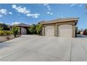 Spacious two-car garage and tandem garage with tasteful stone accents and exterior lighting at 3518 W Agate Ave, Las Vegas, NV 89139