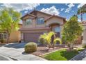 Inviting two-story home with arched entryway, two-car garage, and lush front yard landscaping at 3800 Crema Ct, Las Vegas, NV 89129
