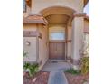 Inviting front entrance with double doors, arched window, and desert landscaping at 3800 Crema Ct, Las Vegas, NV 89129
