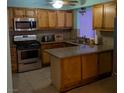 Traditional kitchen with stainless steel appliances, wooden cabinets, and tiled flooring at 5268 Gains Mill St, Las Vegas, NV 89122