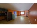 Open-concept living room featuring tile floors, window with blinds, and access to the kitchen at 5268 Gains Mill St, Las Vegas, NV 89122