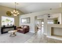 Inviting living room with plush carpet, chandelier, and large windows allowing for natural light at 5437 Escallonia St, Las Vegas, NV 89149