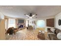 Bright living room with a brick fireplace, ceiling fan, and neutral decor at 6397 Kell Ln, Las Vegas, NV 89156