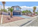 Inviting two-story home with a well-manicured front yard, desert landscaping, and a spacious driveway at 6401 Goldmine Dr, Las Vegas, NV 89156