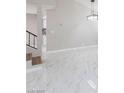 Spacious living room featuring bright white walls, tile floors, and staircase at 6401 Goldmine Dr, Las Vegas, NV 89156