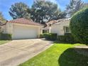 Beautiful single-story house showcasing manicured lawns, mature trees, and a convenient two-car garage at 6987 Emerald Springs Ln, Las Vegas, NV 89113