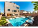The backyard includes a modern in-ground pool and hot tub with surrounding landscaping and fencing at 8179 Shale Canyon St, Las Vegas, NV 89139