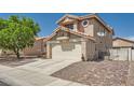 Side view of home featuring large driveway with brick accent, two-car garage, desert landscaping, and small fenced yard at 8324 Brittany Harbor Dr, Las Vegas, NV 89128