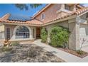 Front exterior of home featuring desert landscaping, brick-lined sidewalk, arched window and solar panels at 8324 Brittany Harbor Dr, Las Vegas, NV 89128