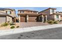 Charming two-story home featuring a three car garage, stone accents, manicured landscaping, and a brick driveway at 844 Aurelie Ridge St, Henderson, NV 89011
