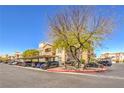 View of condo parking lot with covered parking spots and mature shade tree island at 8777 W Maule Ave # 3102, Las Vegas, NV 89148