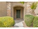 Inviting front entrance with a stylish dark green door and stone accents at 9144 Irish Elk Ave, Las Vegas, NV 89149